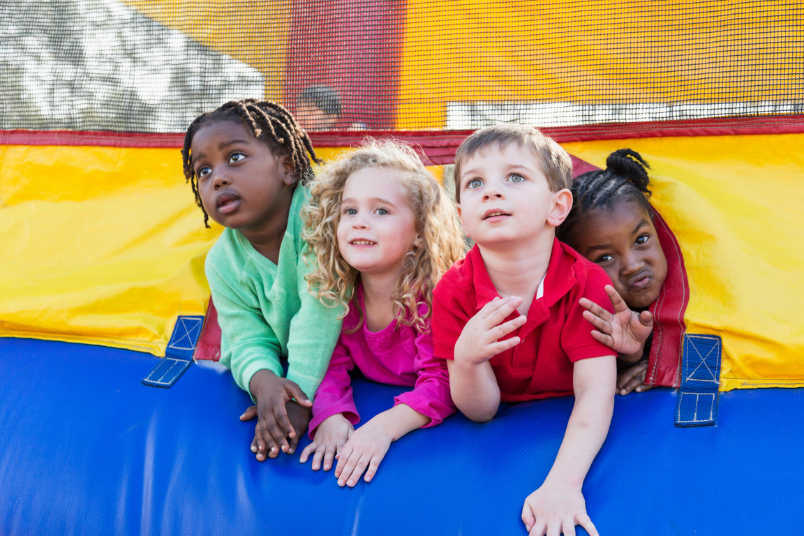 Four multi-ethnic children playing in bounce house