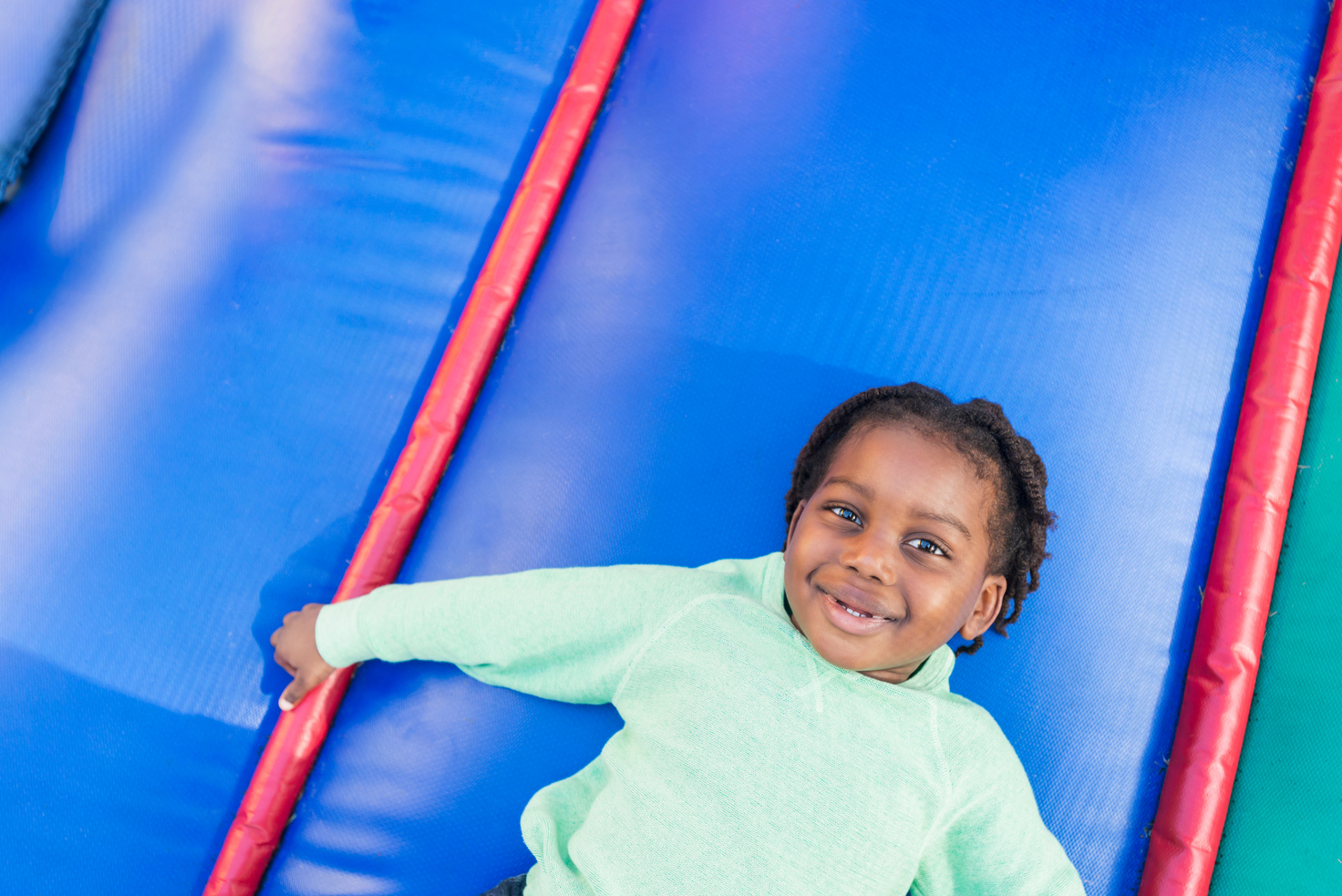 Black boy playing in bounce house